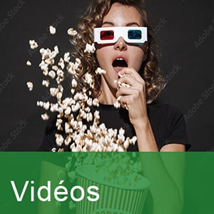 Jeune fille portant des lunettes 3D et mangeant du pop-corn au cinéma